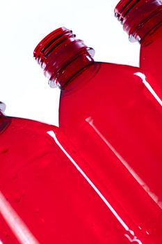 Close up of empty red plastic bottles with a white background