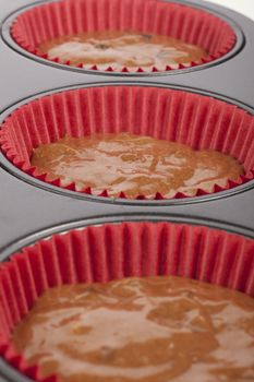 Chocolate cupcake or muffin batter in muffin pan.