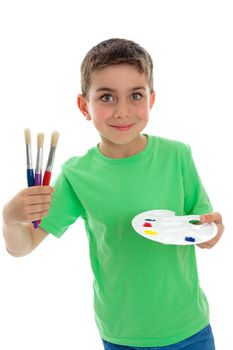 A beautiful smiling young boy holding artist paints and brushes.  White background.