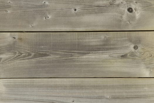 Pine wood boards laying horizontal with knots and grain textures providing a background.