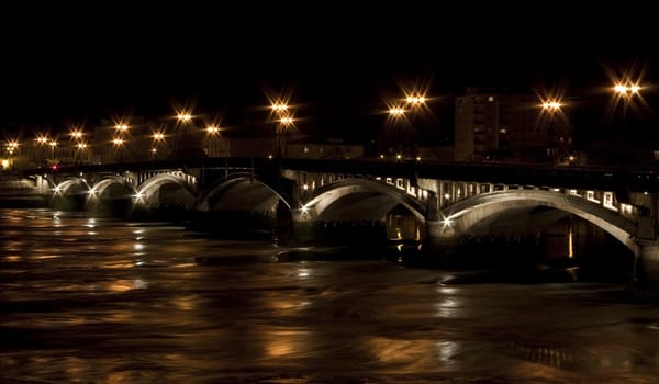 Stone bridge through a river during the night