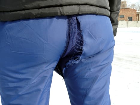 Hole in the blue sport trousers