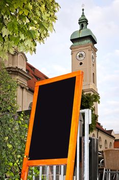 An image of a black board in front of a church in munich