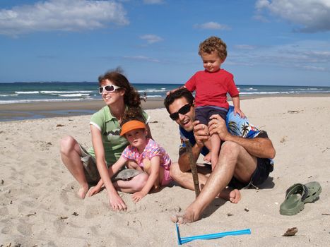 Family of four enjoying a summers day at the beach.