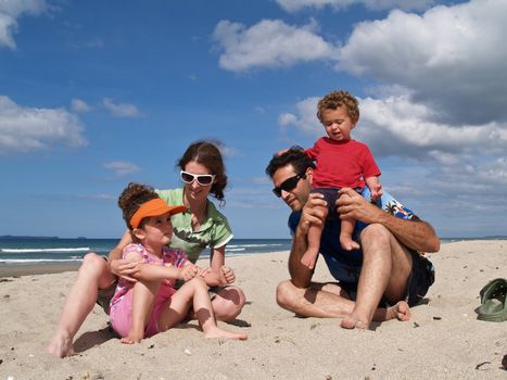 Family of four enjoying time together at the beach.