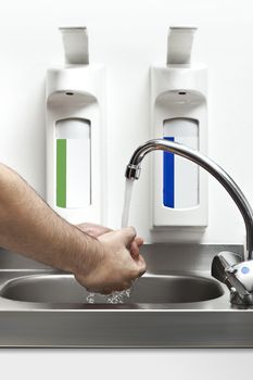 A handsome young man is washing his hands