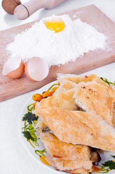 Flour, eggs and other bakery ingredients on wooden board