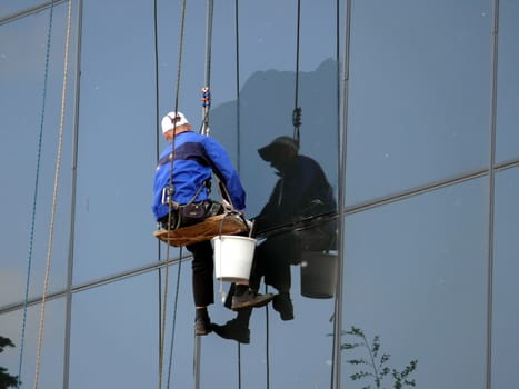 Man washes windows in skycraper
