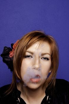 View of a beautiful woman having a smoke on a sensual style.