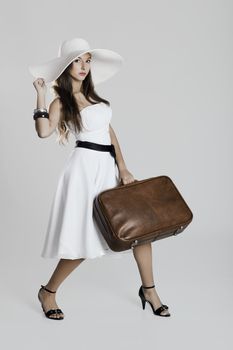 Fashion woman posing with a old suitcase and a white dress