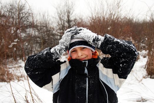 teenage smiling caucasian boy outdoor over winter snowy background