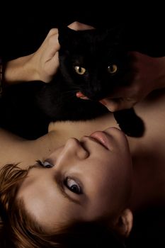 View of a beautiful woman on the bed with a black cat.