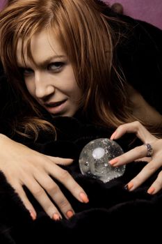 View of a beautiful woman on the bed with a transparent glass ball.