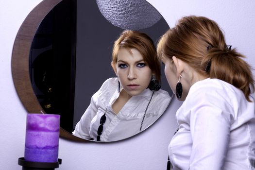 View of a beautiful woman looking at her on a mirror.