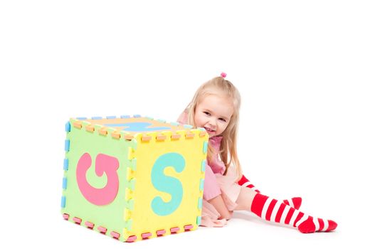 Studio shot of little girl who plaing with cube