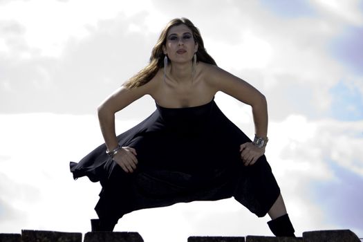 View of a beautiful woman with black dresson a fashion pose.