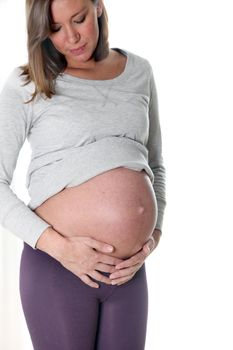 Pregnant woman smiling - in front of white background