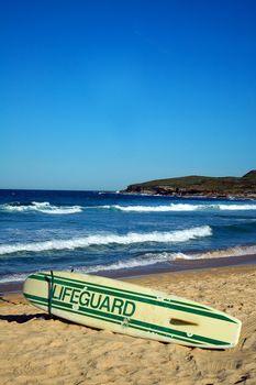 abandoned lifeguard surf, empty sandy beach, clear blue sky