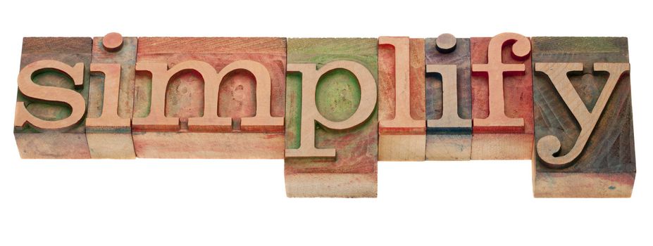 simplify- word in vintage wooden letterpress printing blocks, stained by color inks, isolated on white