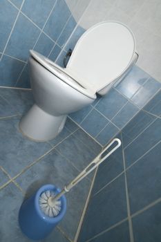 white toilet and cleaning brush vertical photo, tiled walls and floor