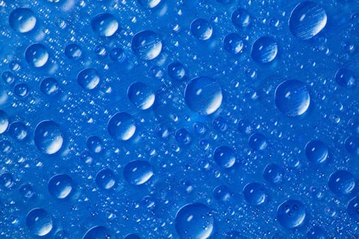 many drops of water on blue background