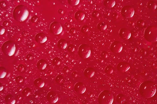 many drops of water on red background