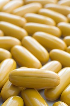several yellow pills on white background, shallow depth of view