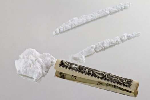 Cocaine cutted at mirror and ready to be sniffed trough a one dollar bill