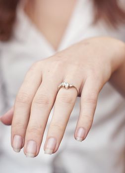 an image of engagement ring inserted into finger