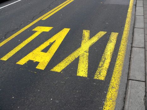 Yellow road sign on asphalt - Taxi. Belgrade. Serbia