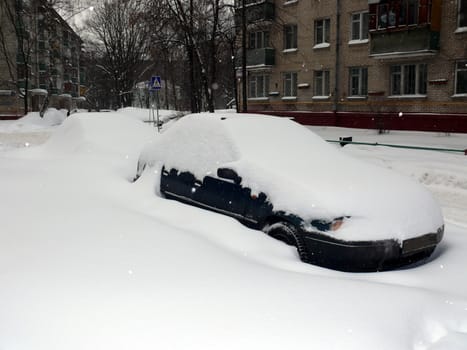 Car in snowdrift after snowfall in Moscow