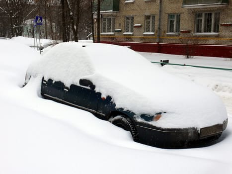 Car in snowdrift after snowfall in Moscow