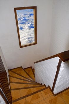 Staircase with open window to a cloudy sky