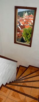 Staircase with window with view to Prague city roofs