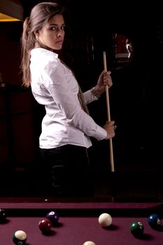 Detail view of a girl next to a snooker table.