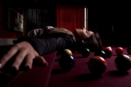 Detail view of a girl next to a snooker table.