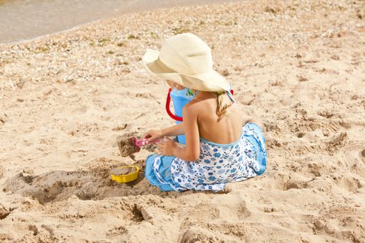 people series: little girl on sea beach are play the sandy game