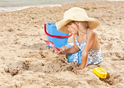 people series: little girl on sea beach are play the sandy game