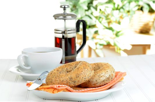Two flax bagels on a plate served with coffee.