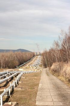 View of pipelines leading to the horizon with power-plant