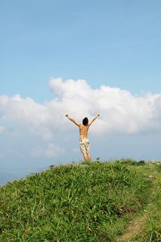 Meeting of the sky. The man on high mountain with the hands lifted above, on a background of blue sky