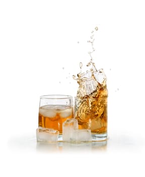Two glasses of splashing whiskey near ice cubes isolated on white background with clipping path