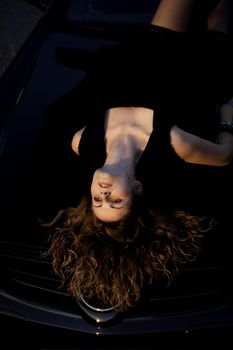 view of a beautiful woman on top of a sports car.