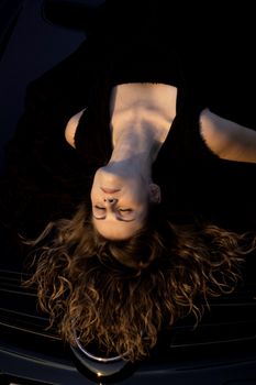 view of a beautiful woman on top of a sports car.