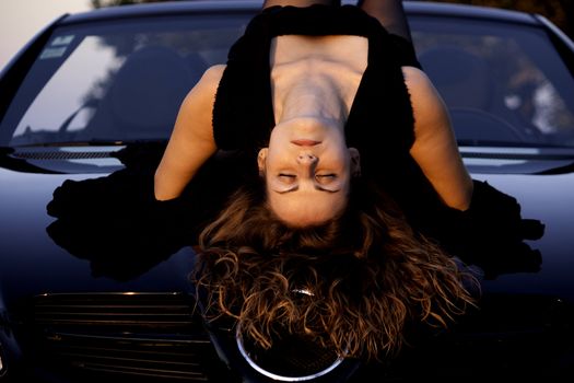 view of a beautiful woman on top of a sports car.