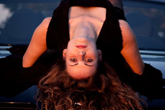 view of a beautiful woman on top of a sports car.