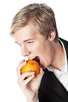 Smiling young handsome blond man biting an orange