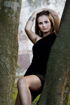 View of a beautiful girl on a black dress on a park.