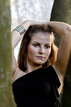 View of a beautiful girl on a black dress on a park.