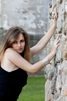 View of a beautiful girl on a black dress on a park.